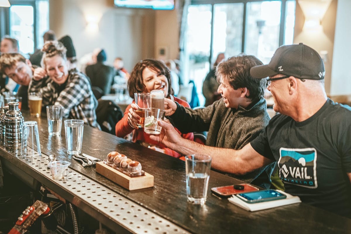 a group of people are drinking from a wine glass on a table