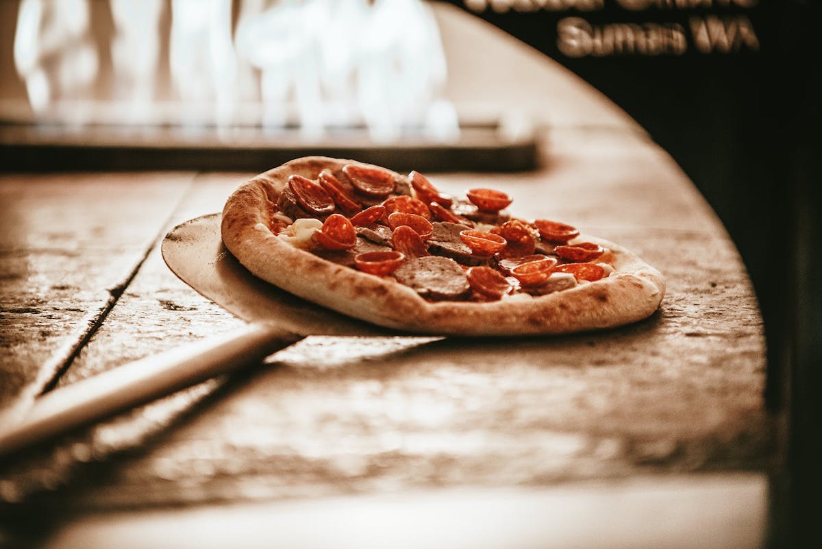 a pizza sitting on top of a wooden cutting board