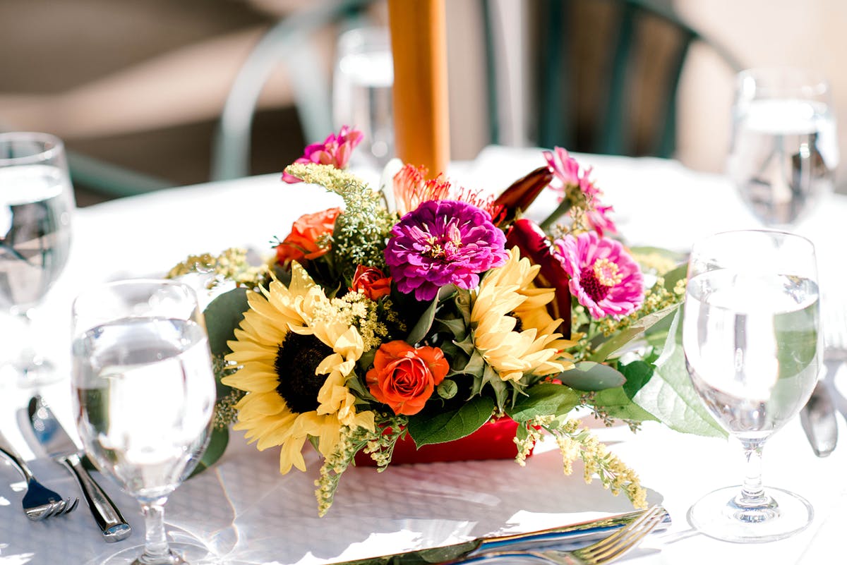 a bouquet of flowers on a table with wine glasses