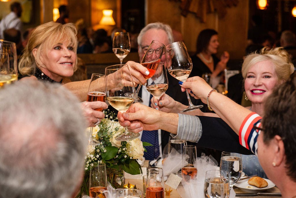 a group of people are drinking from a wine glass