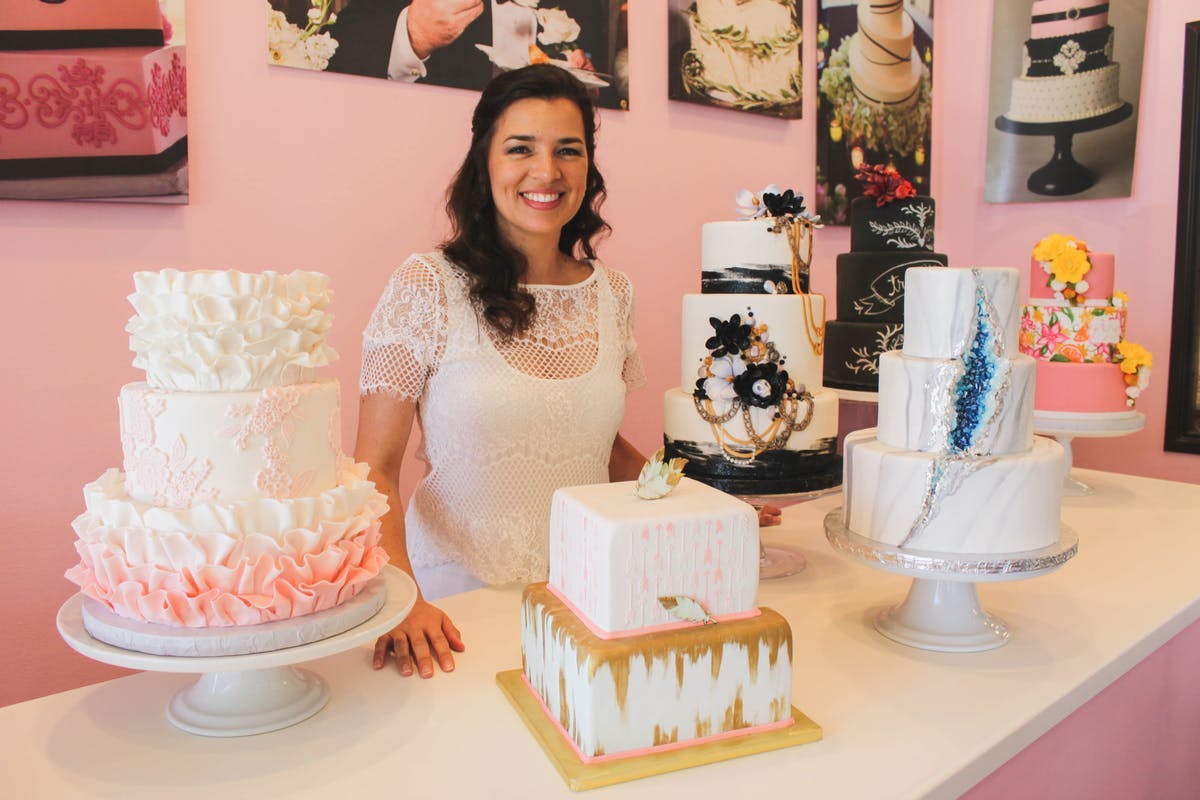a woman sitting at a table with a cake