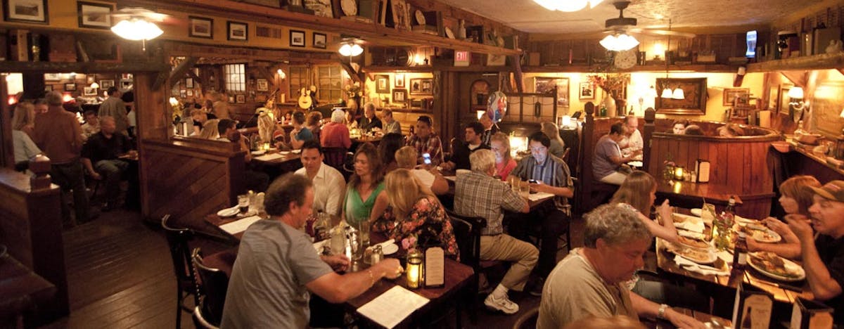 a group of people sitting at different tables in a restaurant