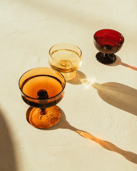 a glass of wine sitting on top of a wooden table