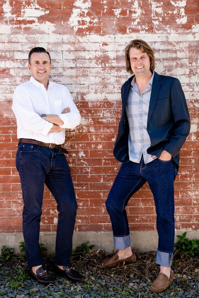 a group of people standing next to a brick wall
