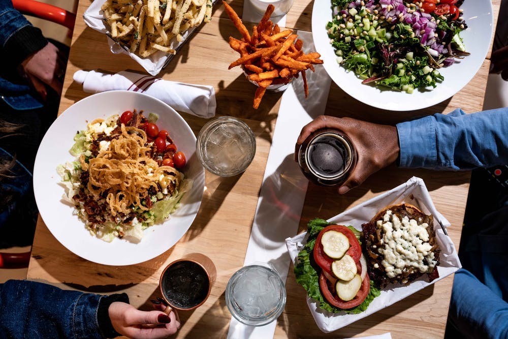 a group of people sitting at a table with a plate of food