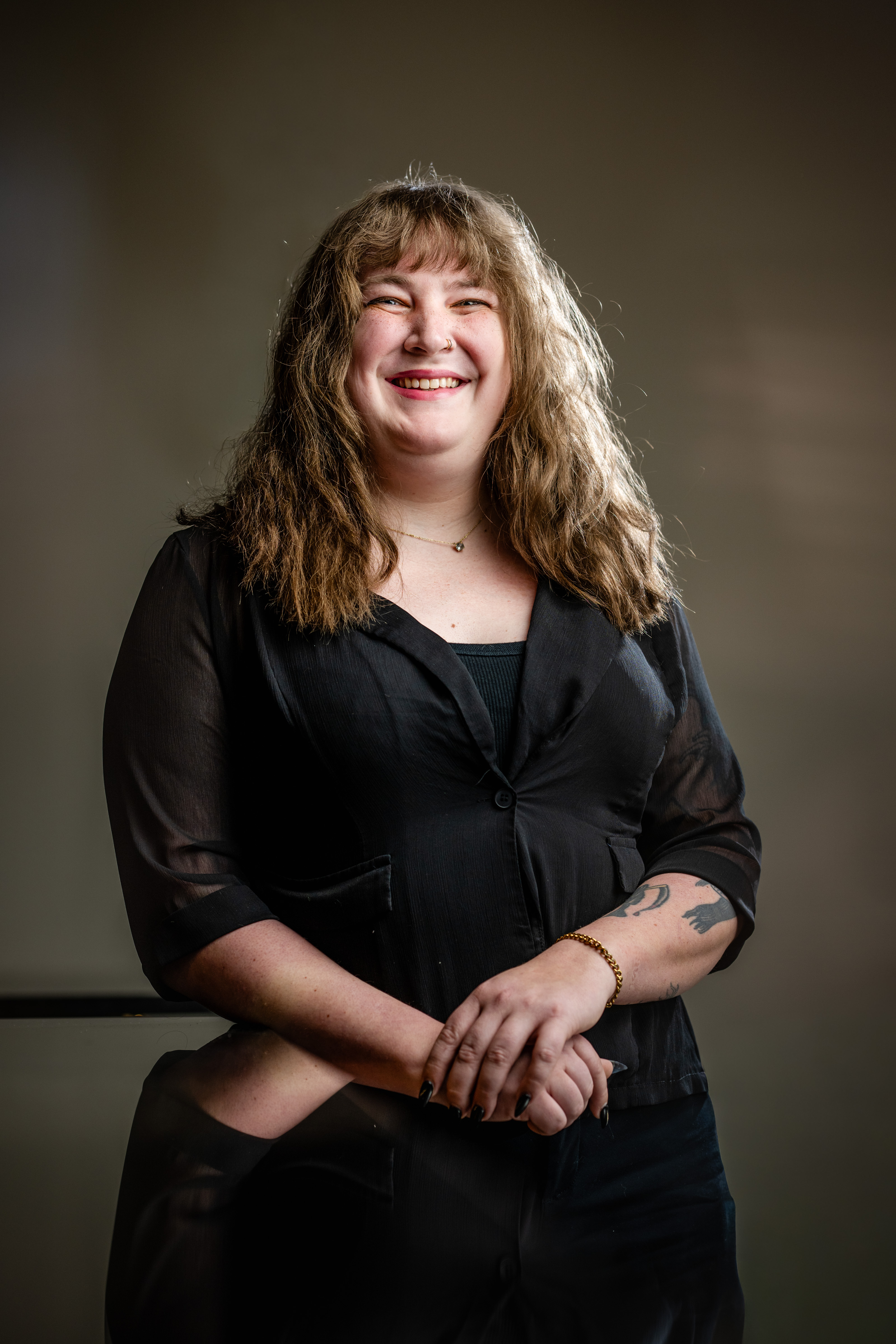 a woman smiling with arms crossed