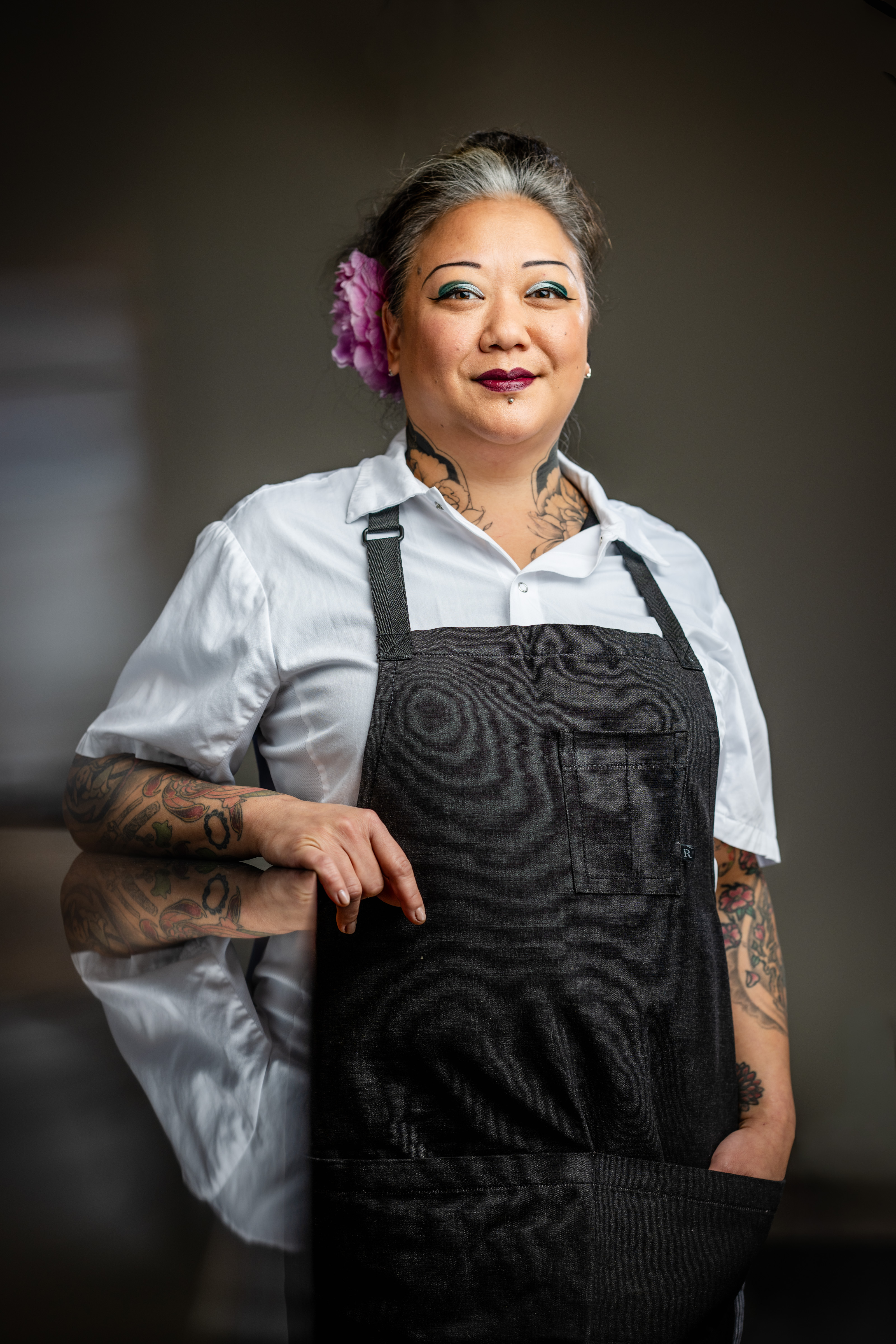a woman with tattoos and a flower in her hair