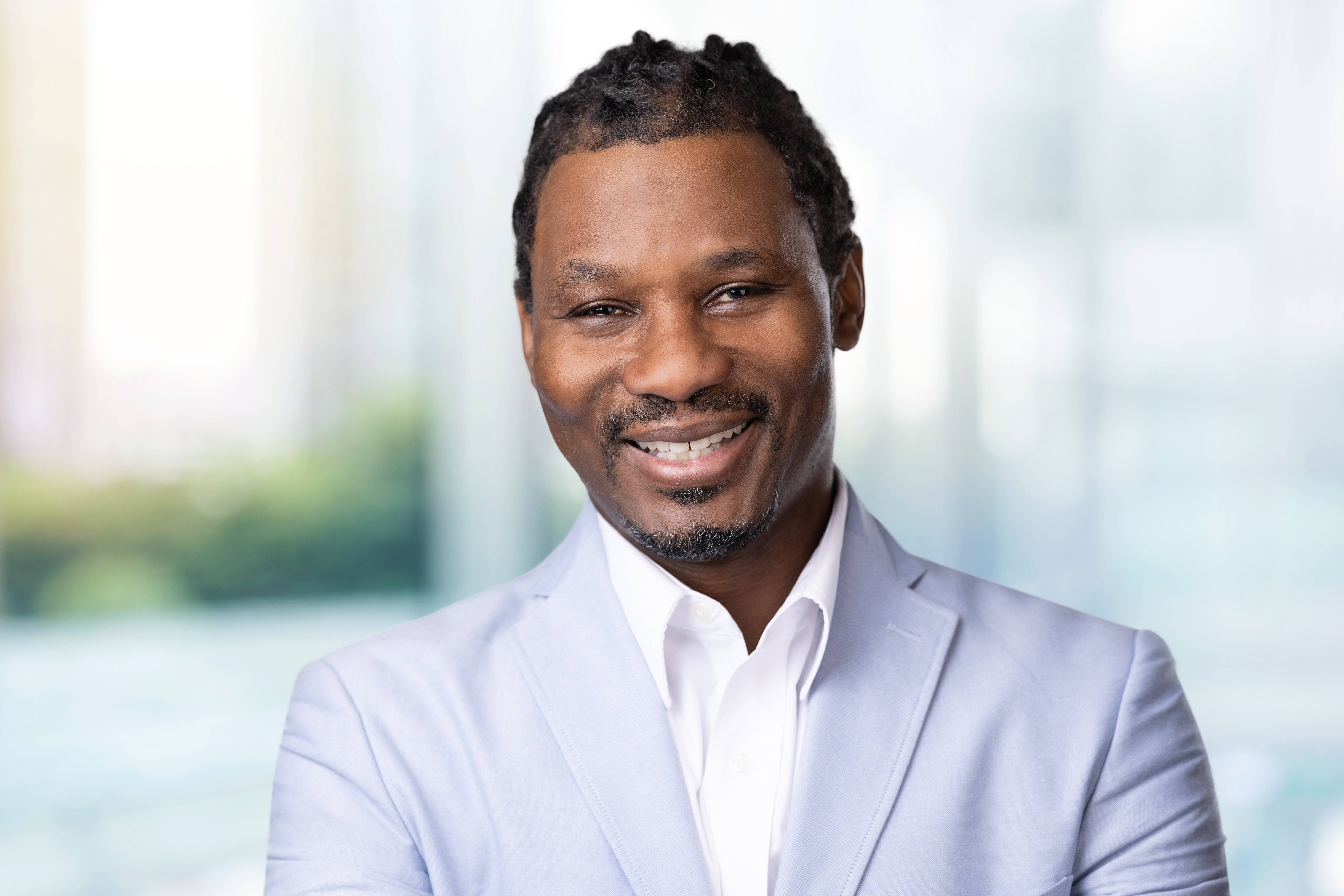 a man wearing a blue light tuxedo and smiling