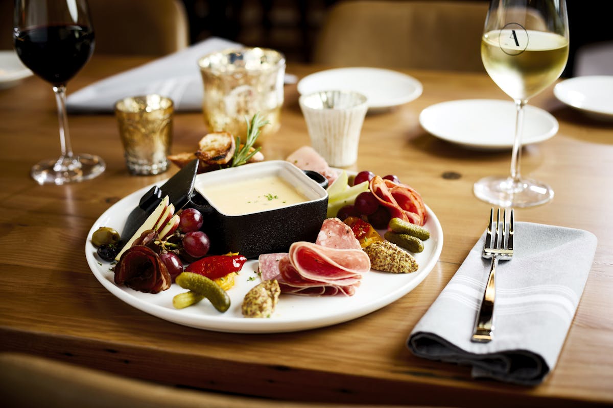 a plate of food and glasses of wine on a table