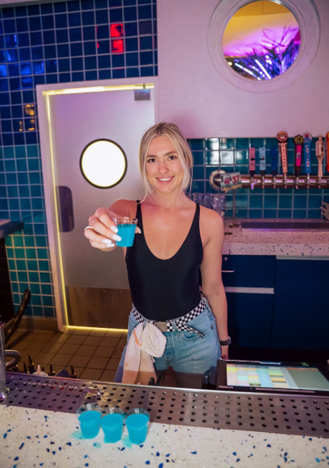 a woman standing in front of a mirror posing for the camera