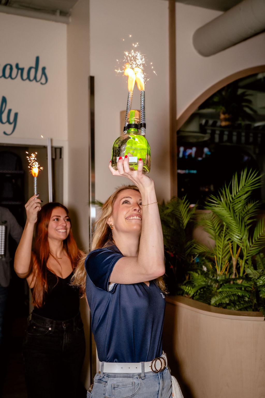 a woman standing in front of a christmas tree