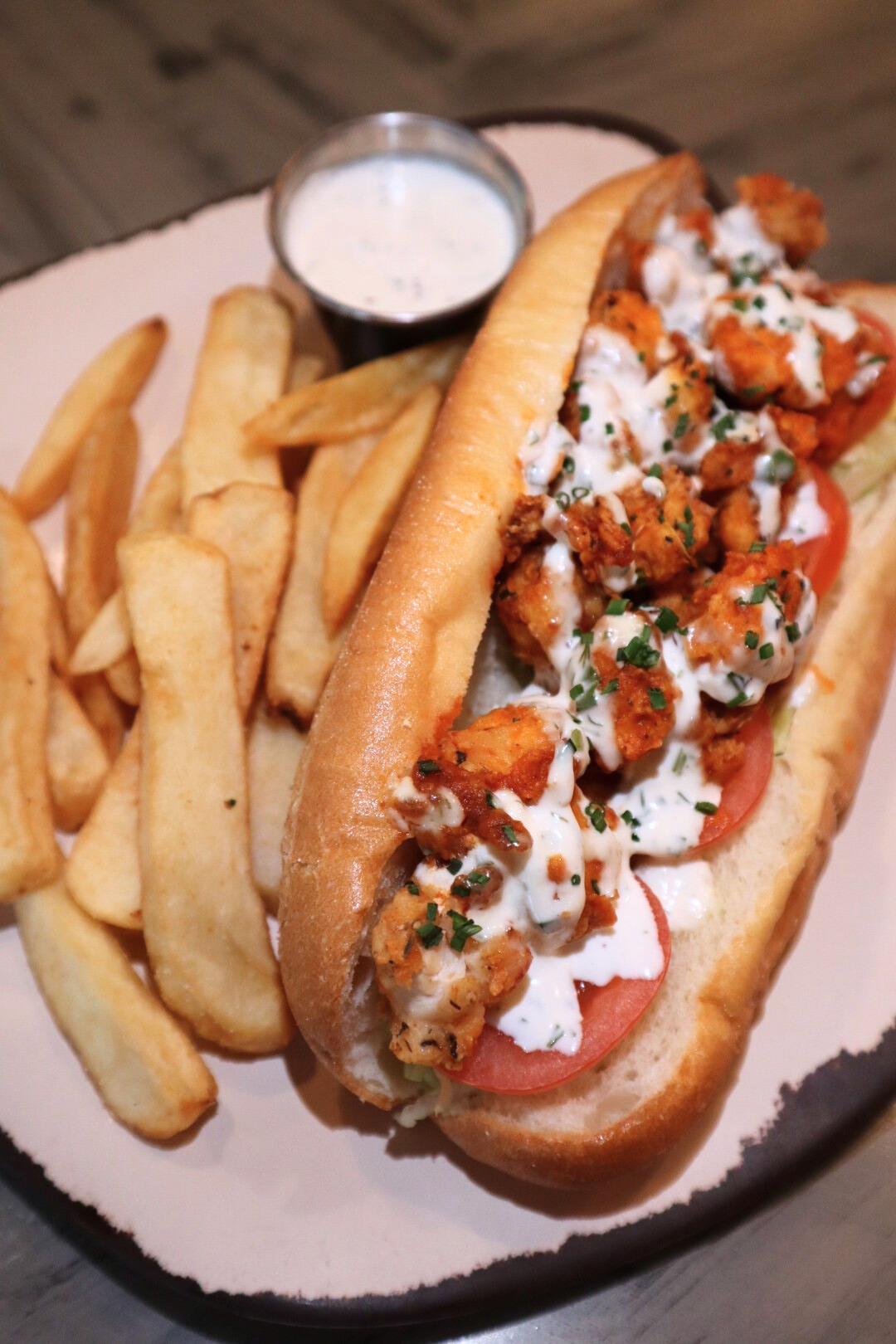 a hot dog on a bun next to some fries