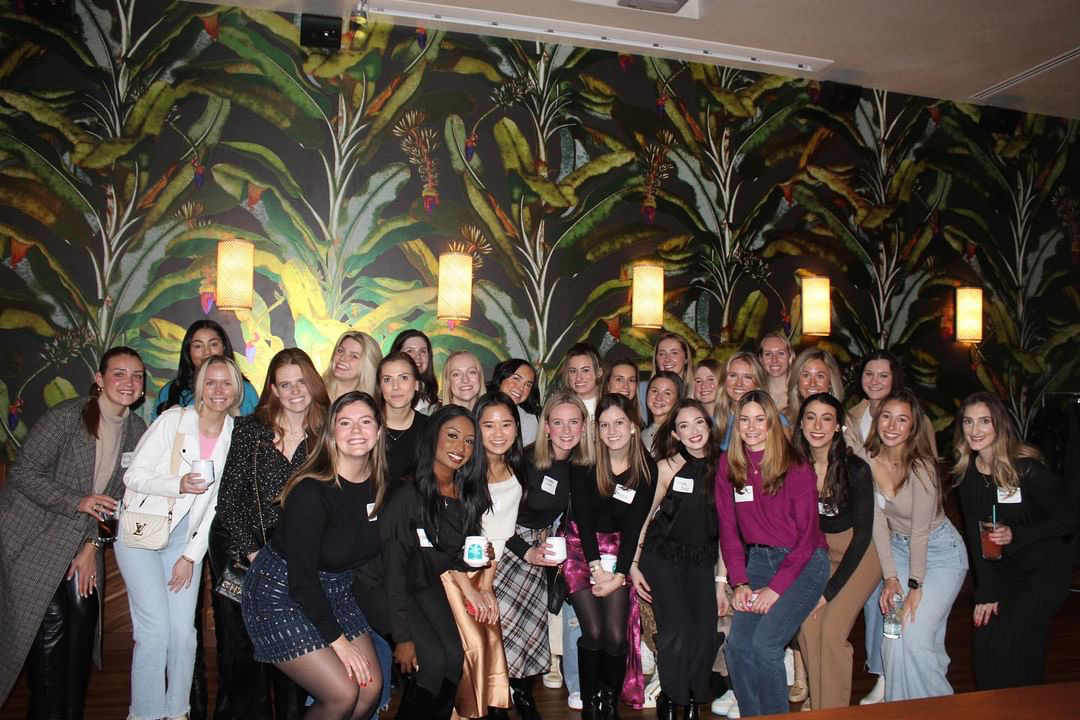 a group of people standing in front of a crowd posing for the camera