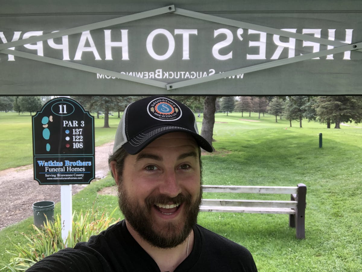a man in a hat smiling for the camera