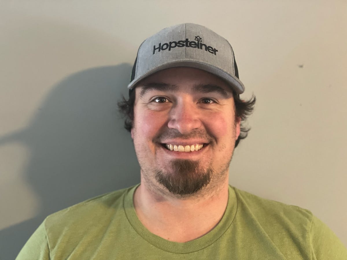 a man wearing a hat and smiling at the camera