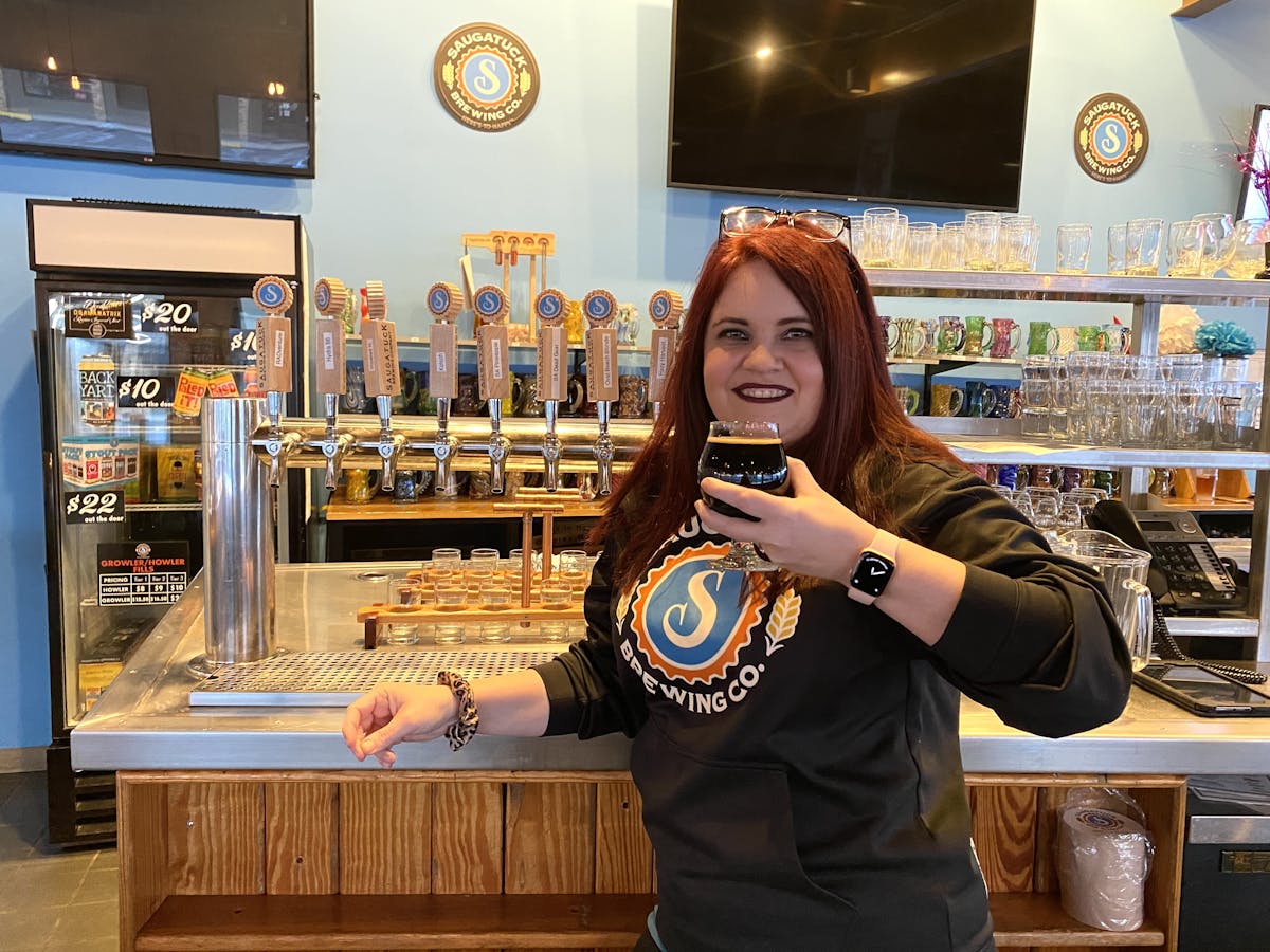 a person standing in front of beers on tap