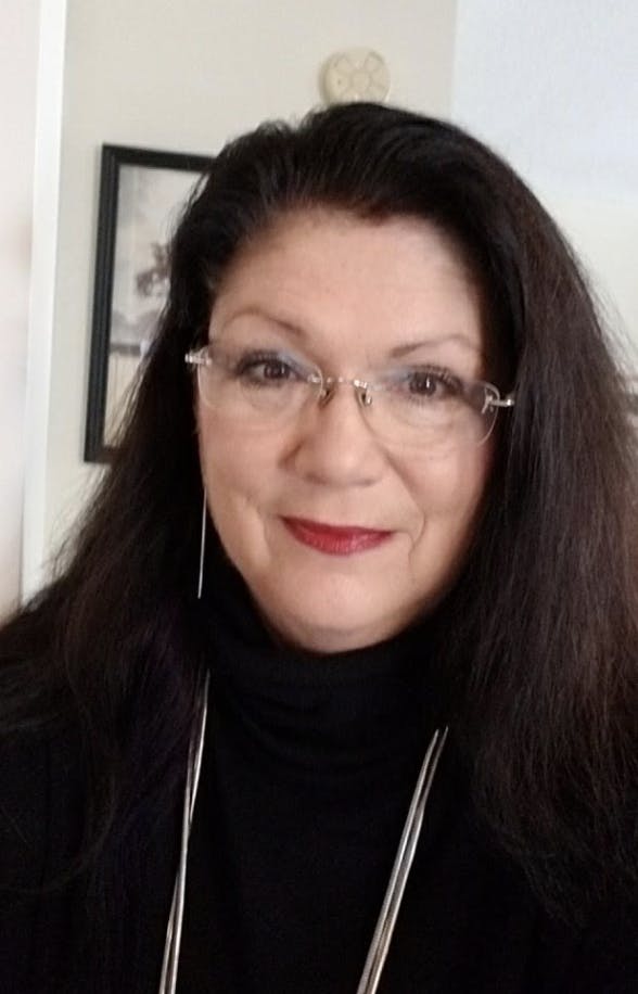 a woman in glasses looking at the camera