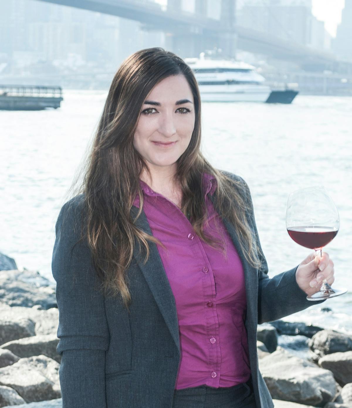 a woman smiling next to a body of water