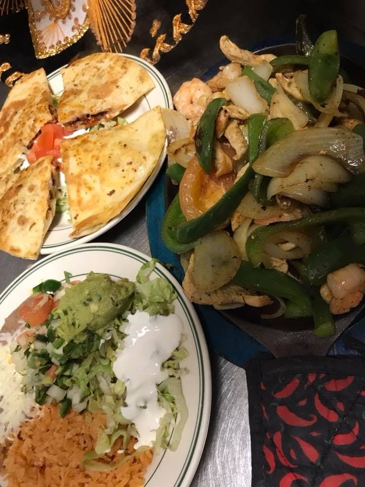 plates with quesadillas, salad and chicken with green rice