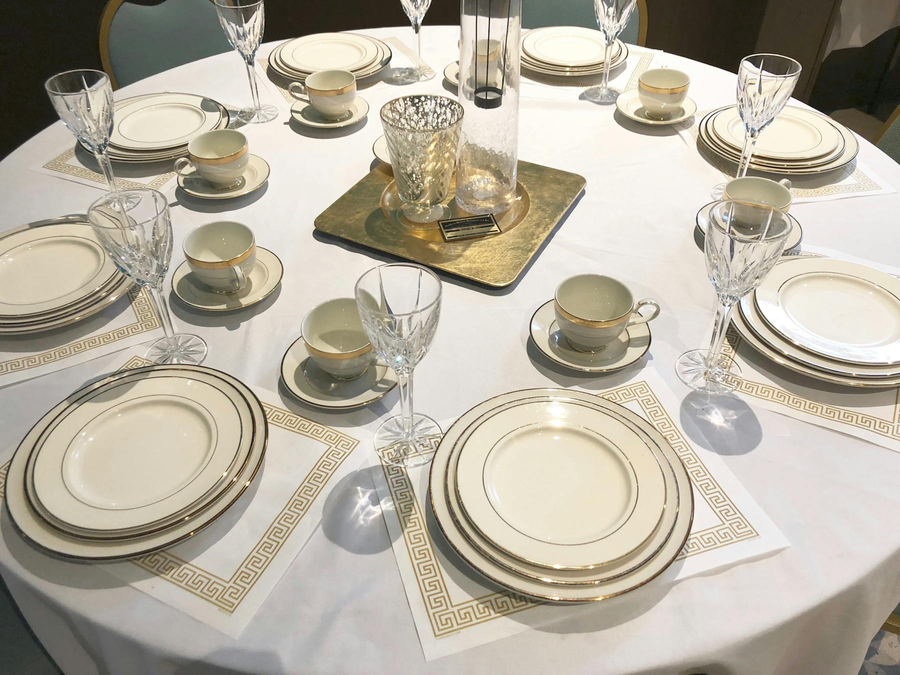 a dining table set with plates and glasses