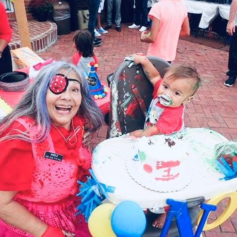 a woman and a child posing with a cake