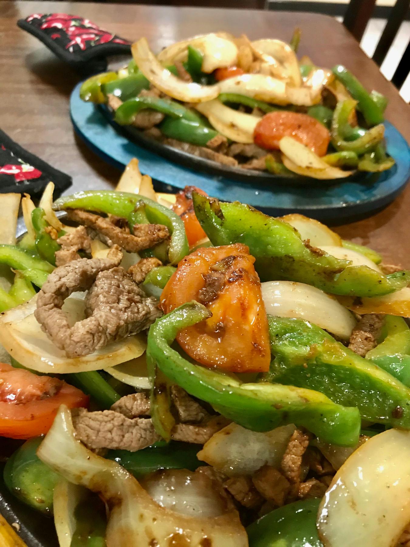 a plate of fajitas and greens
