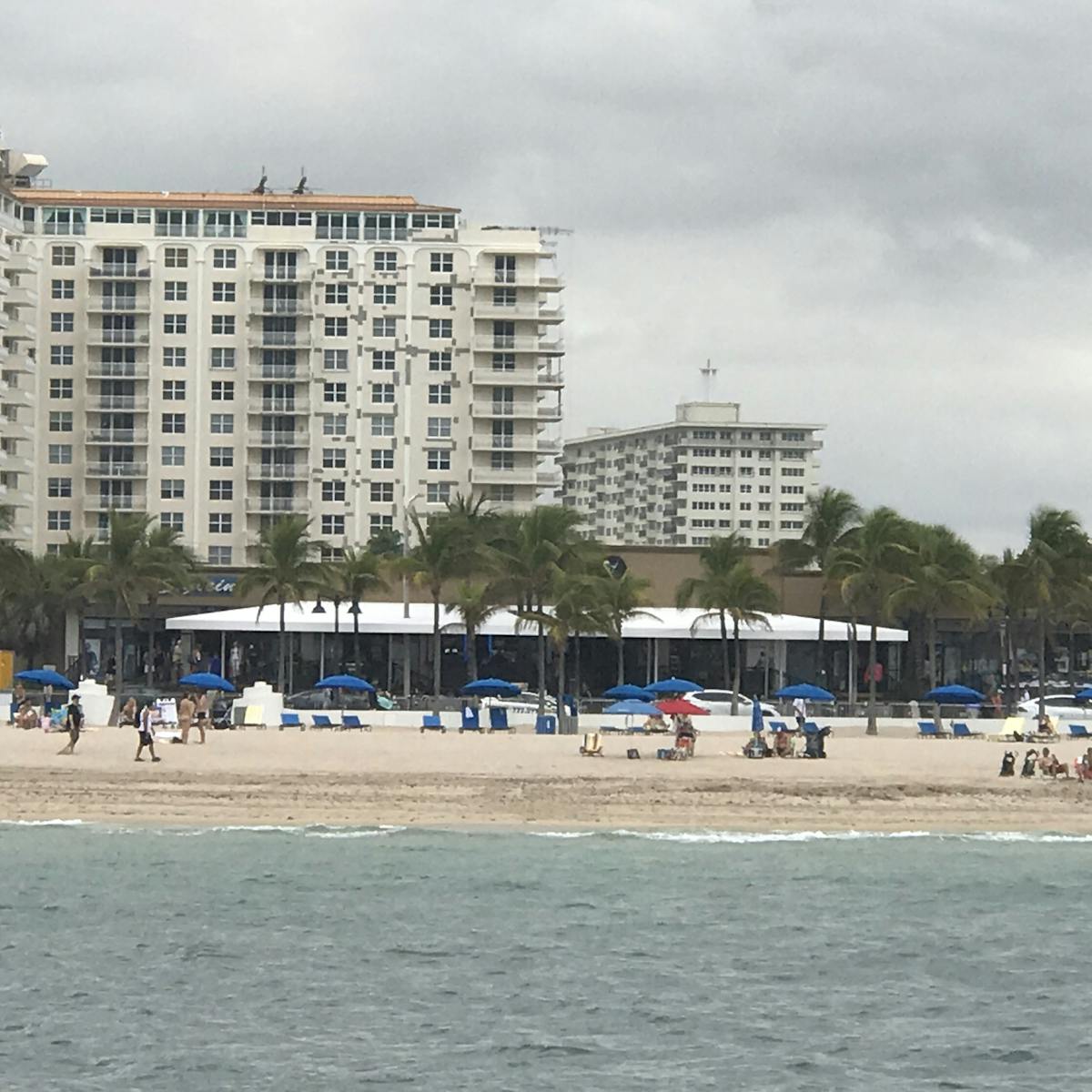 a group of people standing on top of a sandy beach