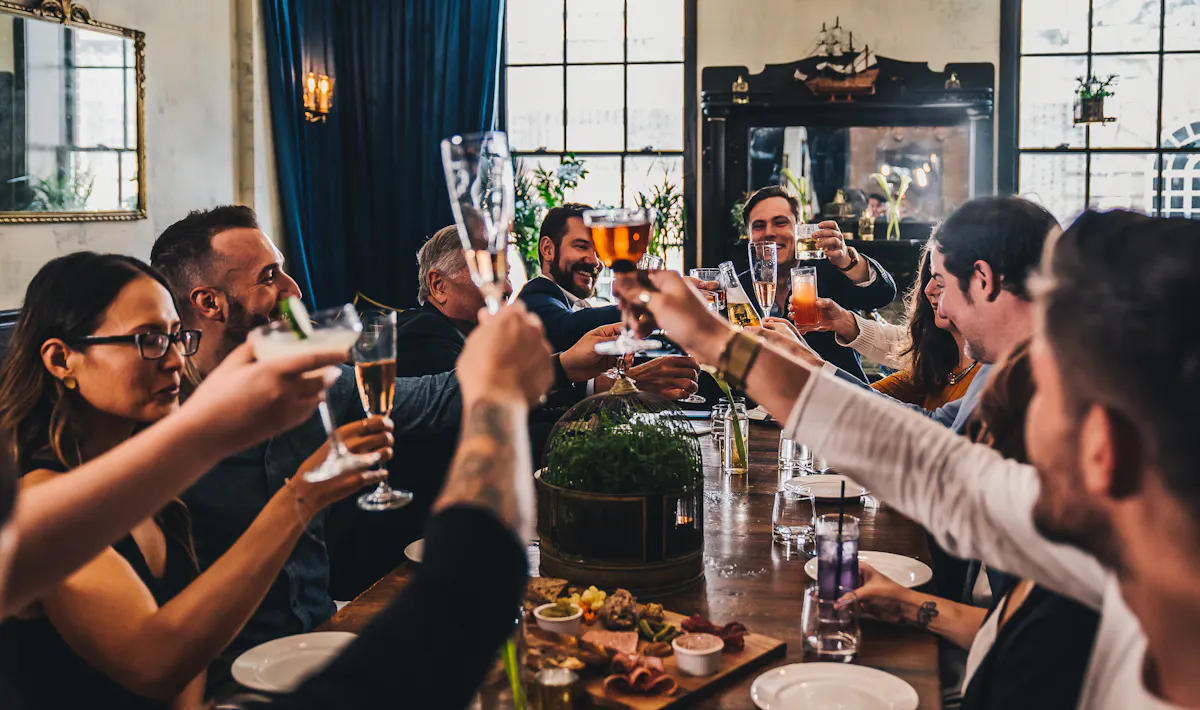 a group of people are drinking from a wine glass