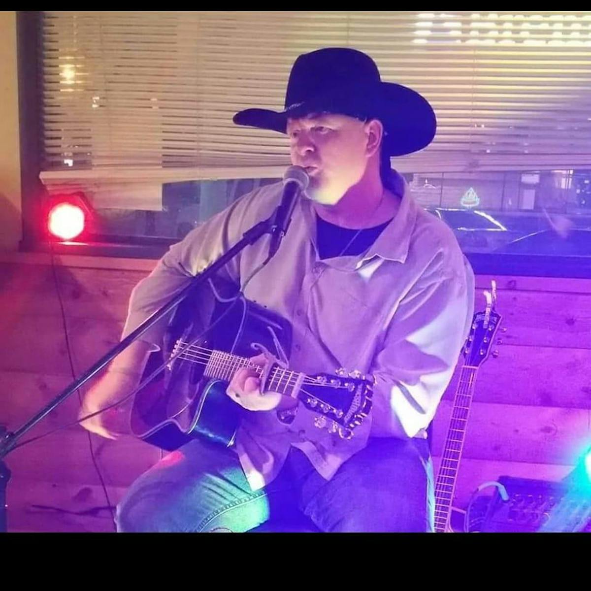 a man wearing a purple hat on stage