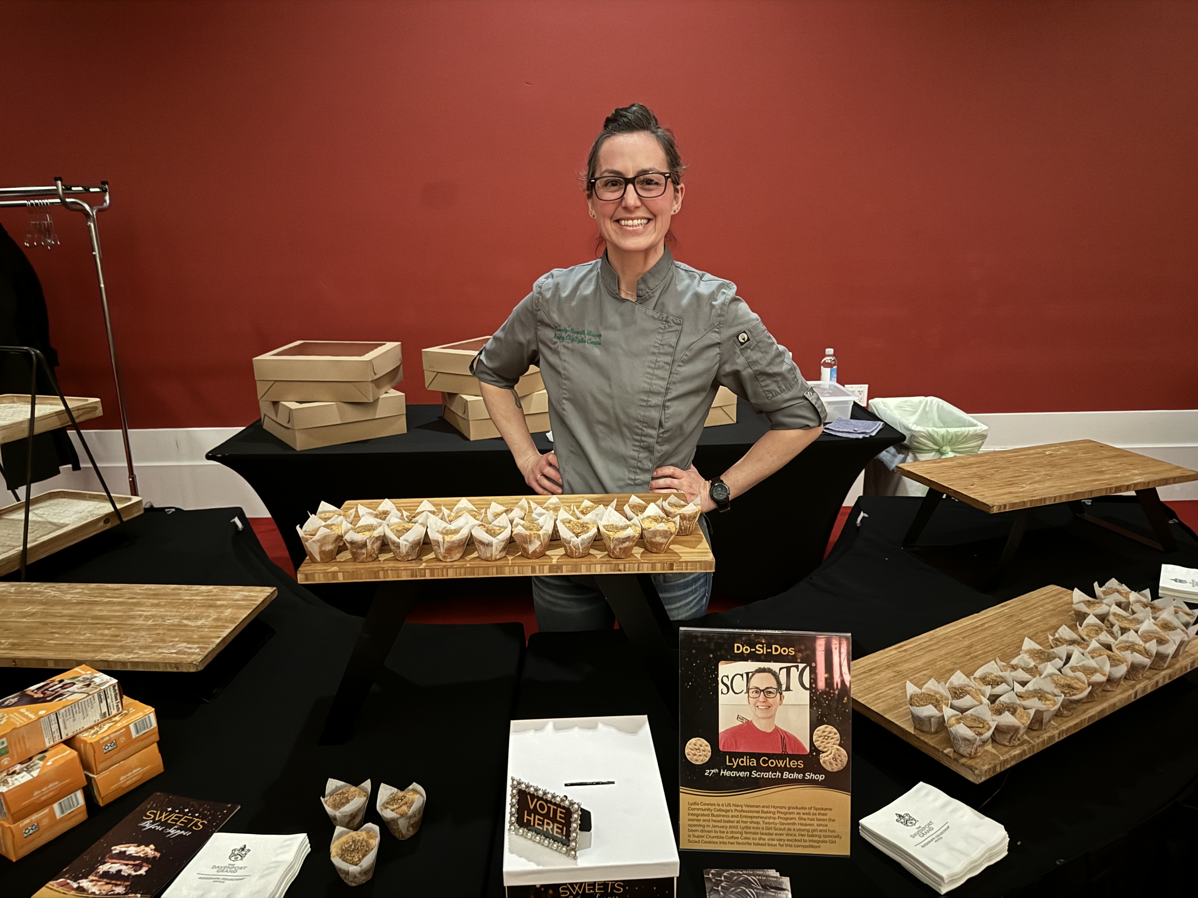 woman standing behind table with treats