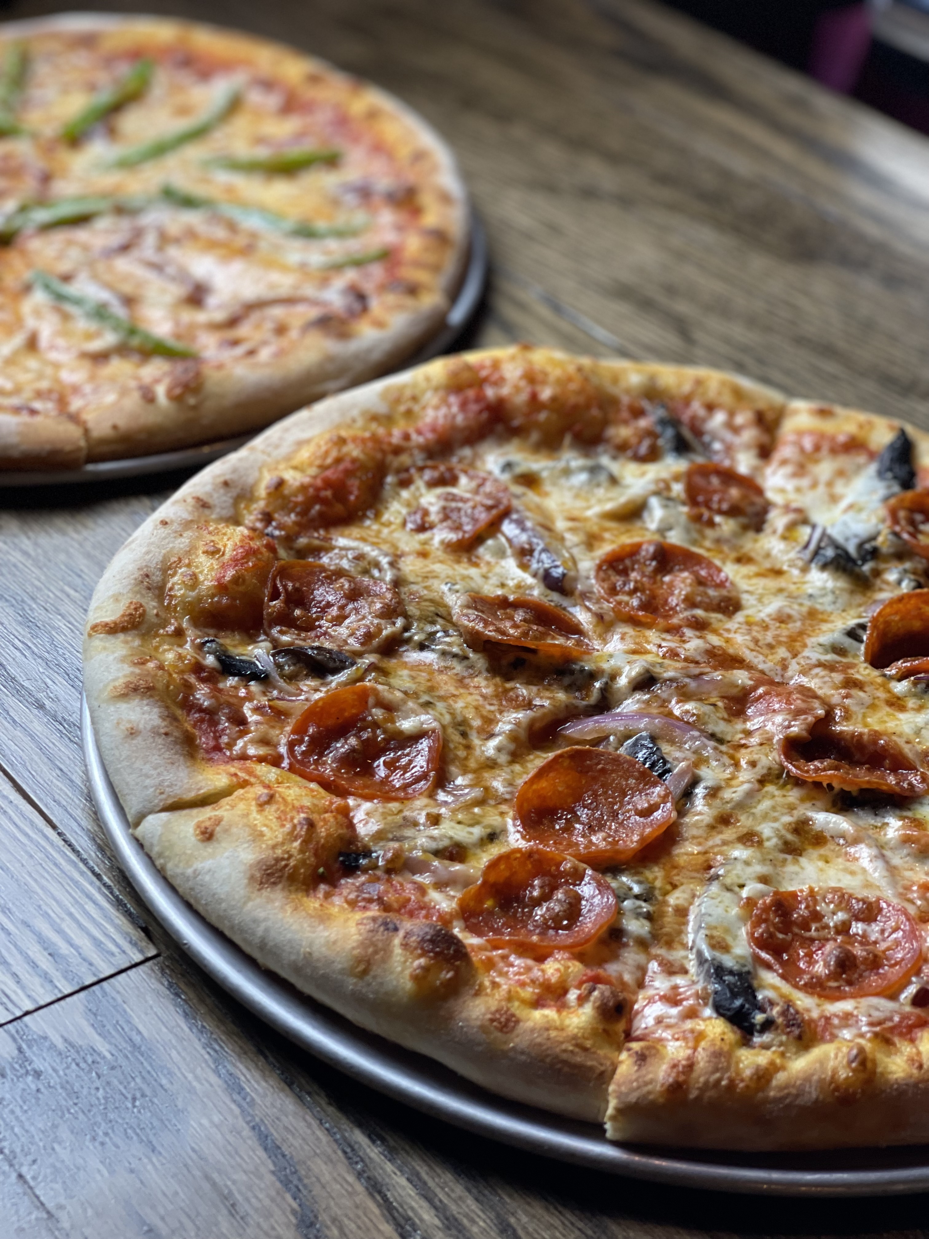 a pizza sitting on top of a wooden table