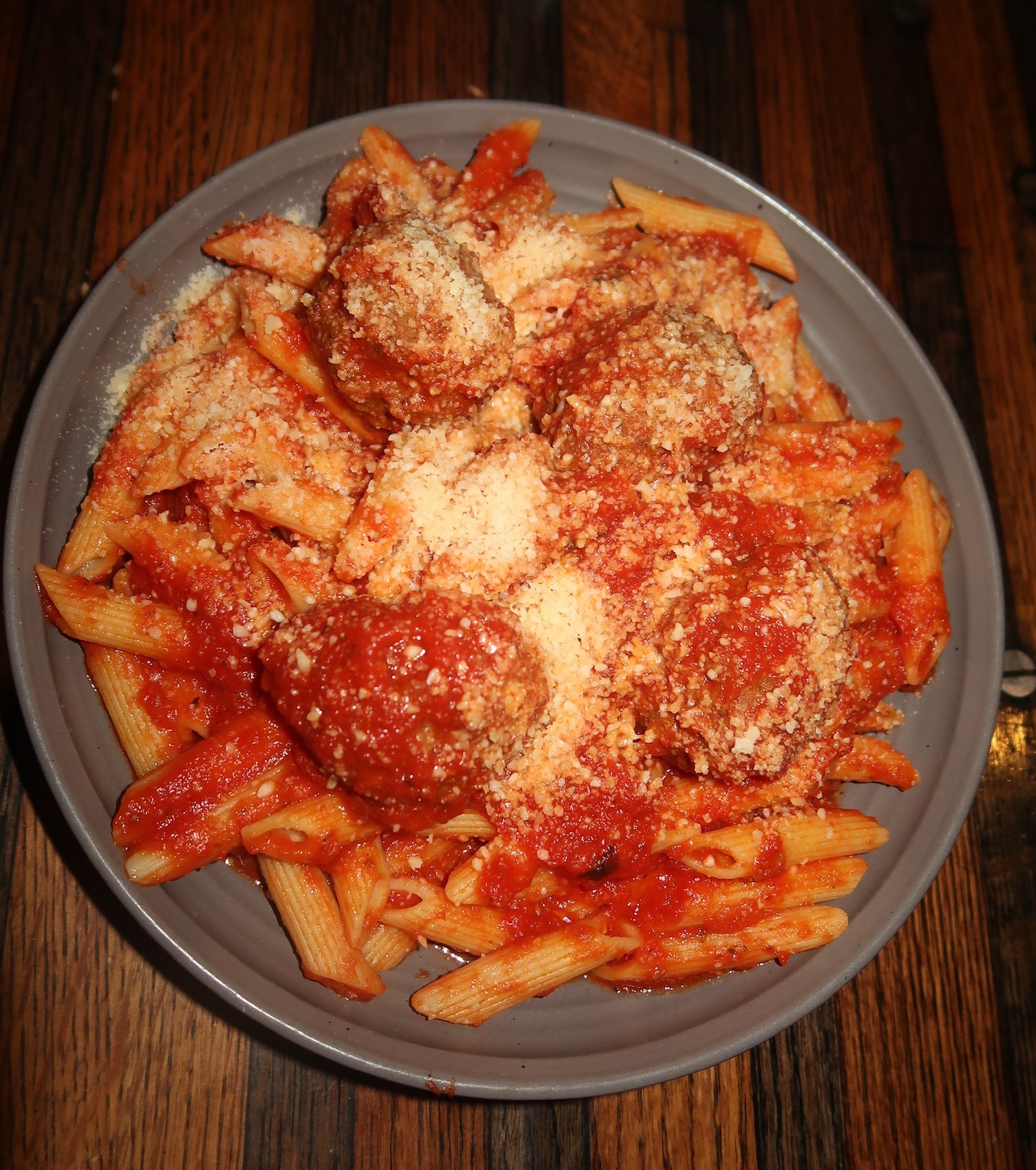 a plate of pasta with meatballs and cheese