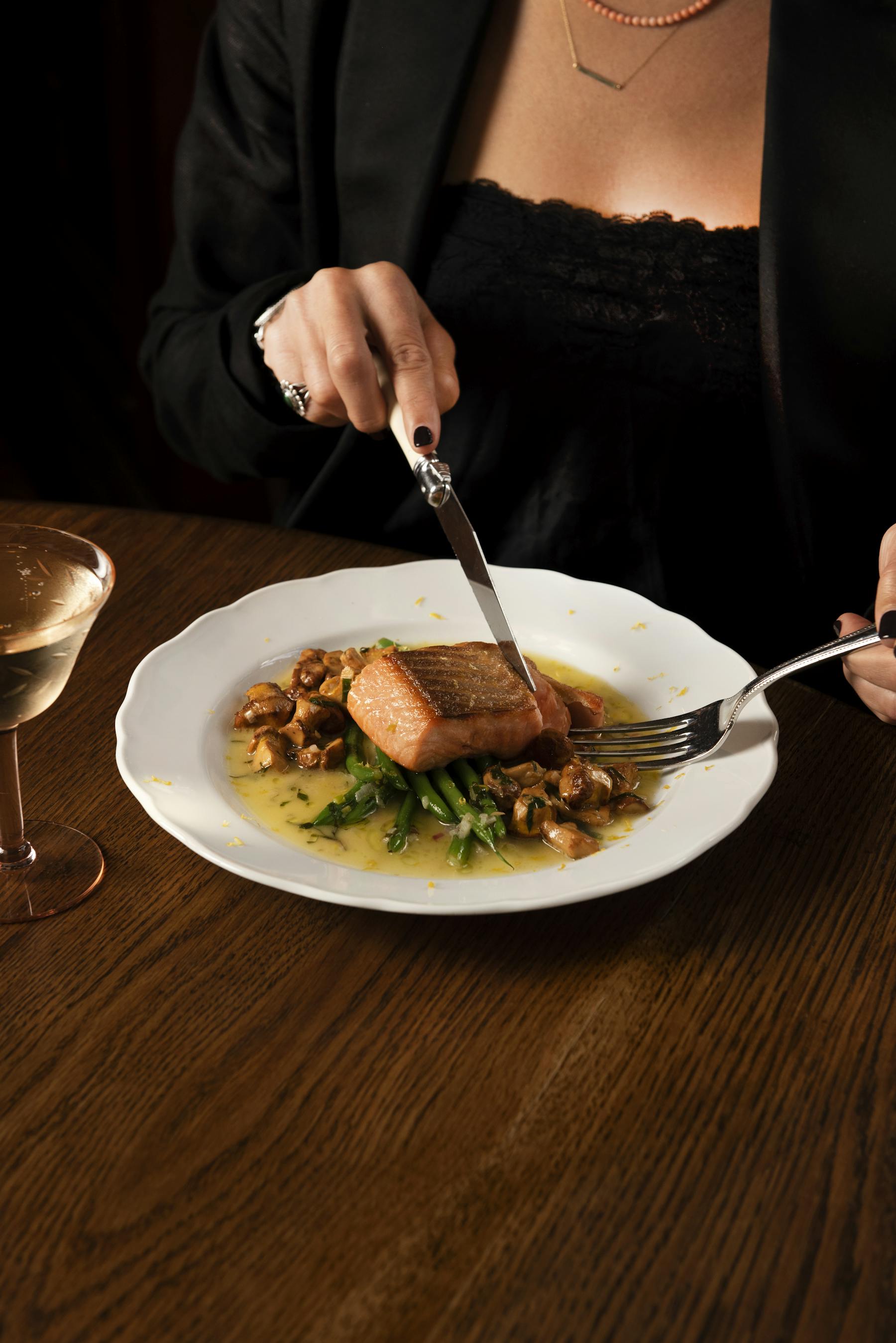 a person sitting at a table with a knife and fork on a plate