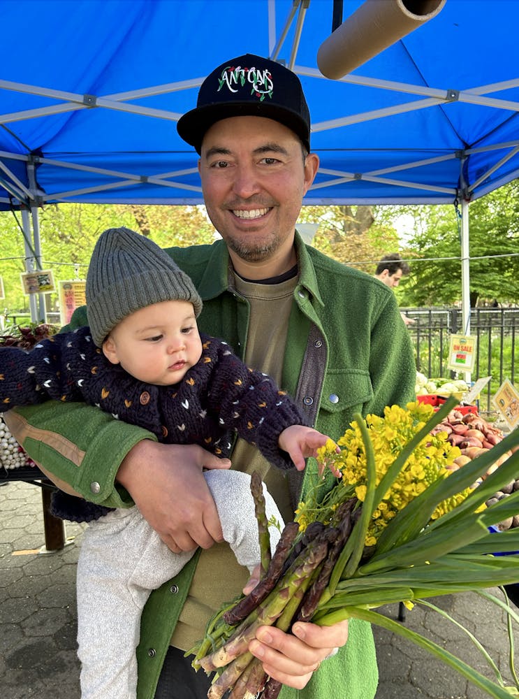 a person holding a baby with a green umbrella