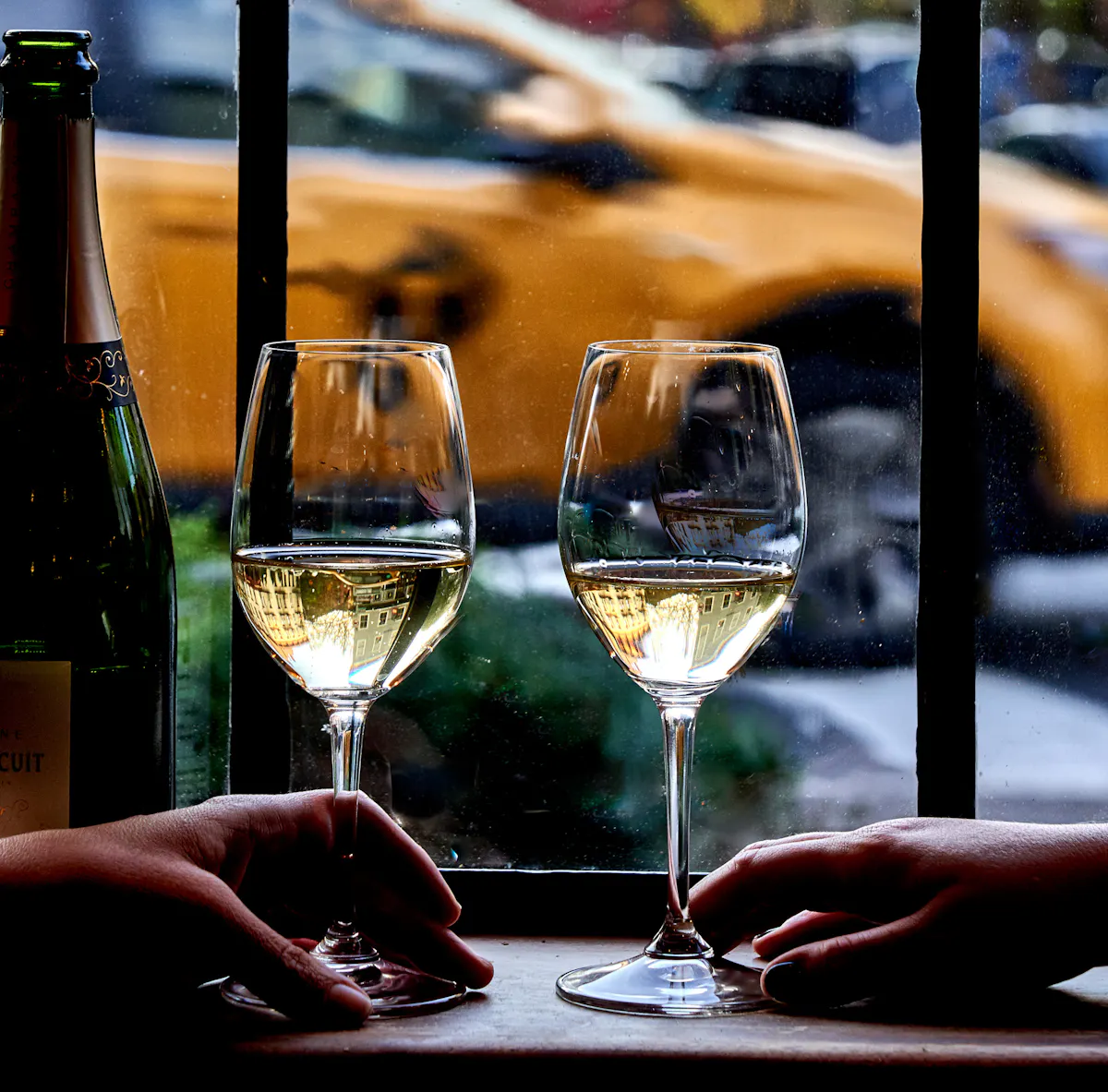 Two wine glasses looking out the window to the West Villag