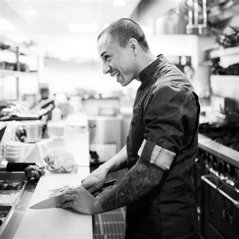 chef cutting a fish in a kitchen