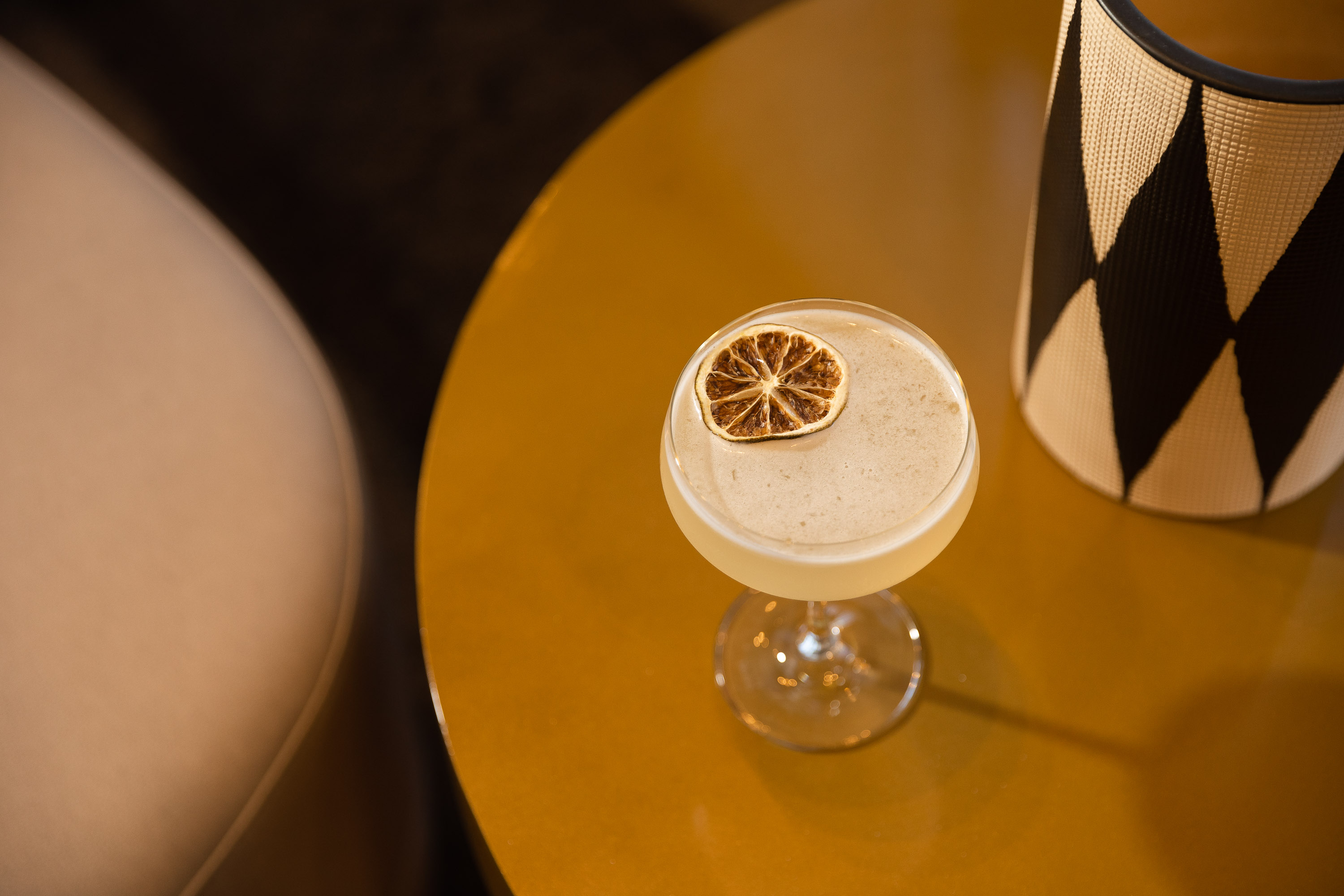 table with an elegant cocktail and slice of orange as garnish