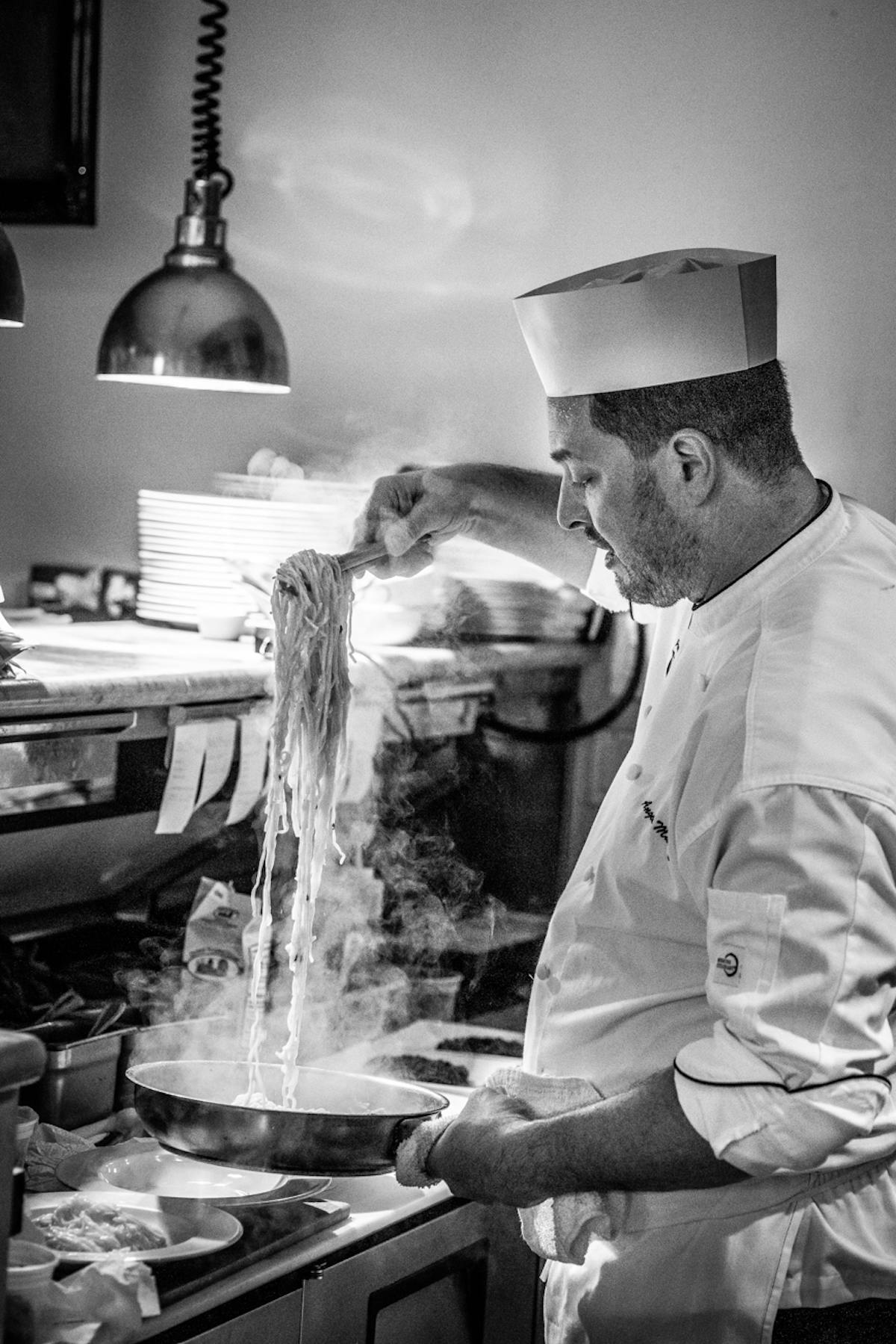 a man standing in a kitchen preparing food