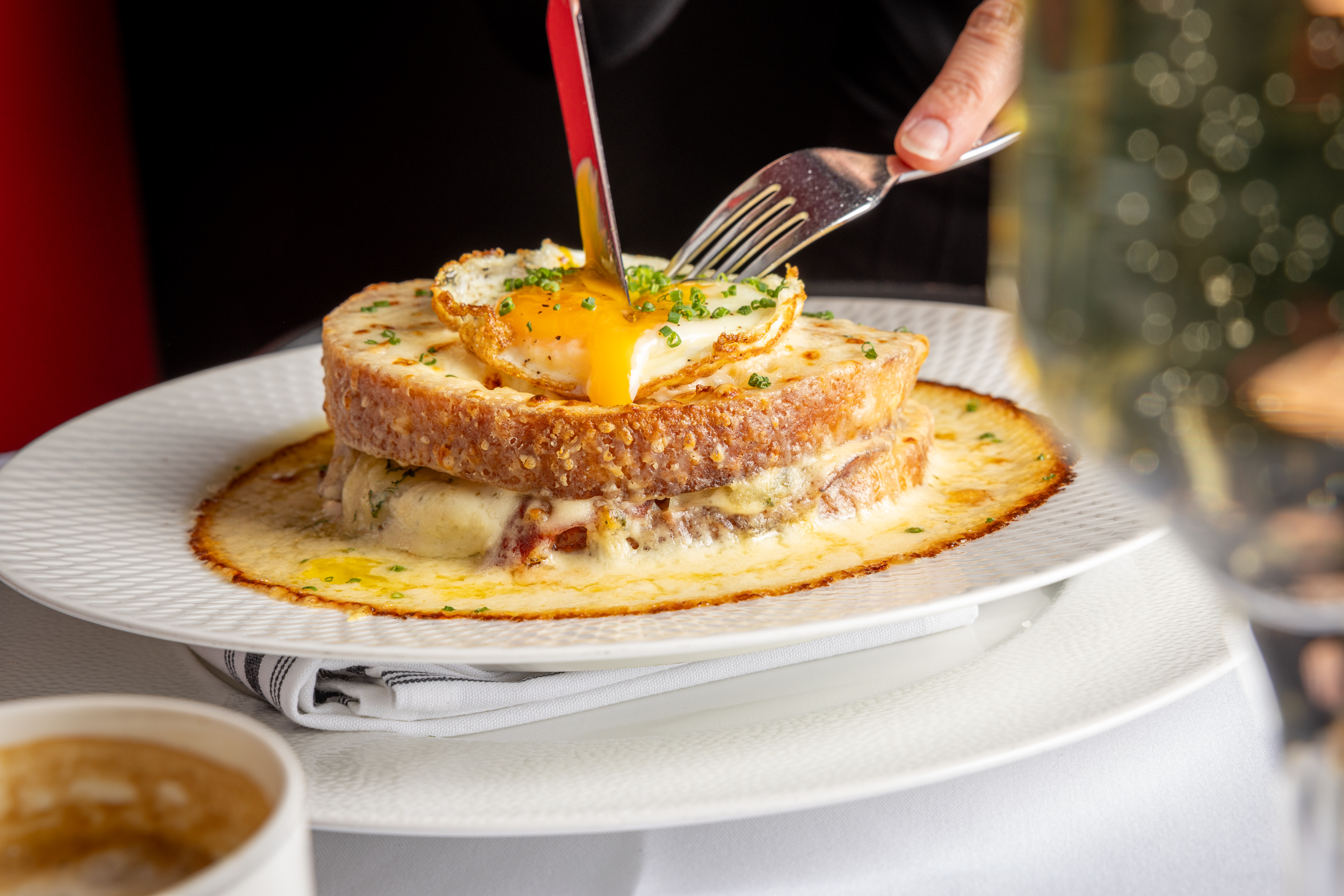 a person holding a fork and knife over a plate of food