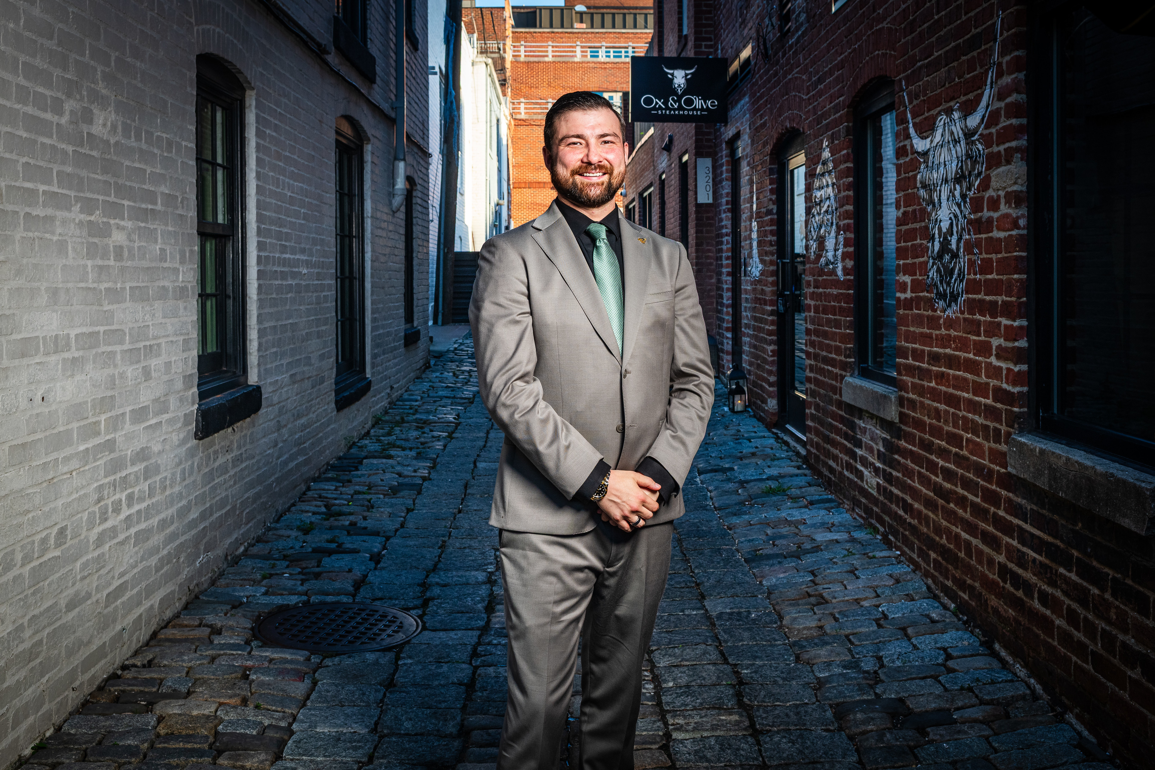 a man in a suit standing in a alley
