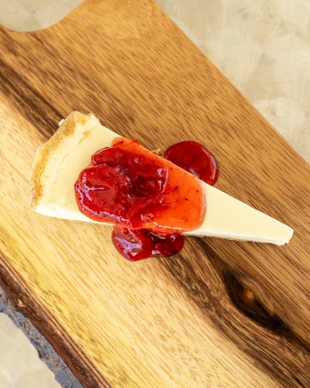 a slice of pizza sitting on top of a wooden cutting board