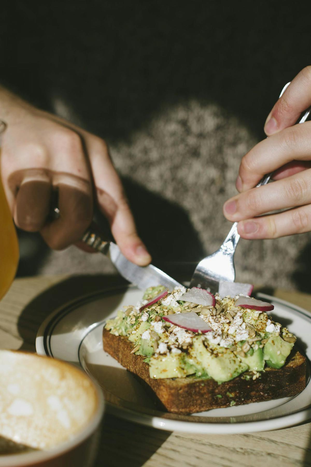 a close up of a person cutting a piece of bread on a plate