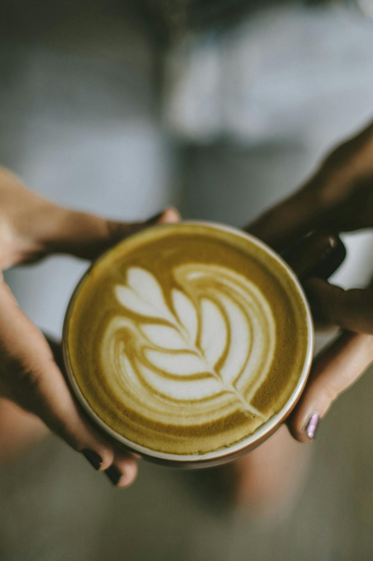 a hand holding a cup of coffee