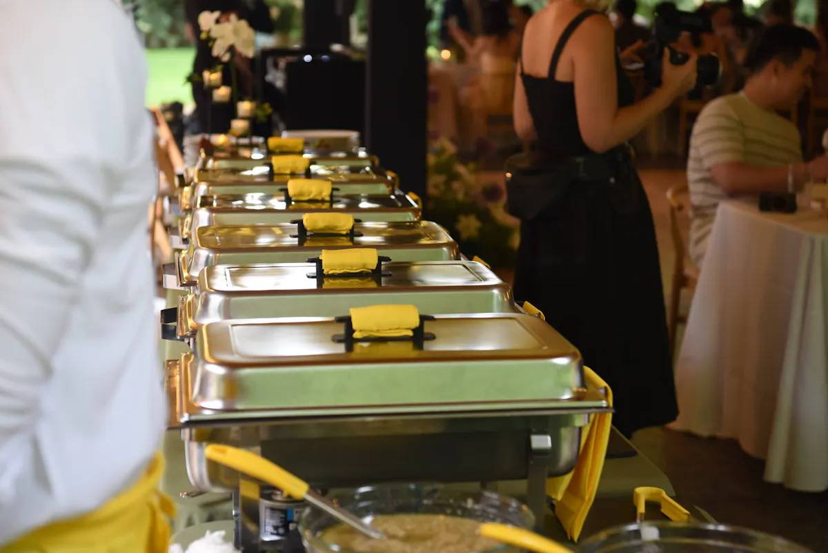 a row of silver containers with yellow napkins on top
