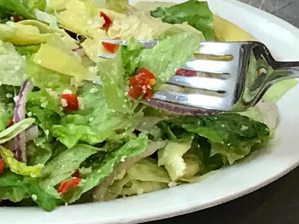 a white plate topped with a sandwich and a salad