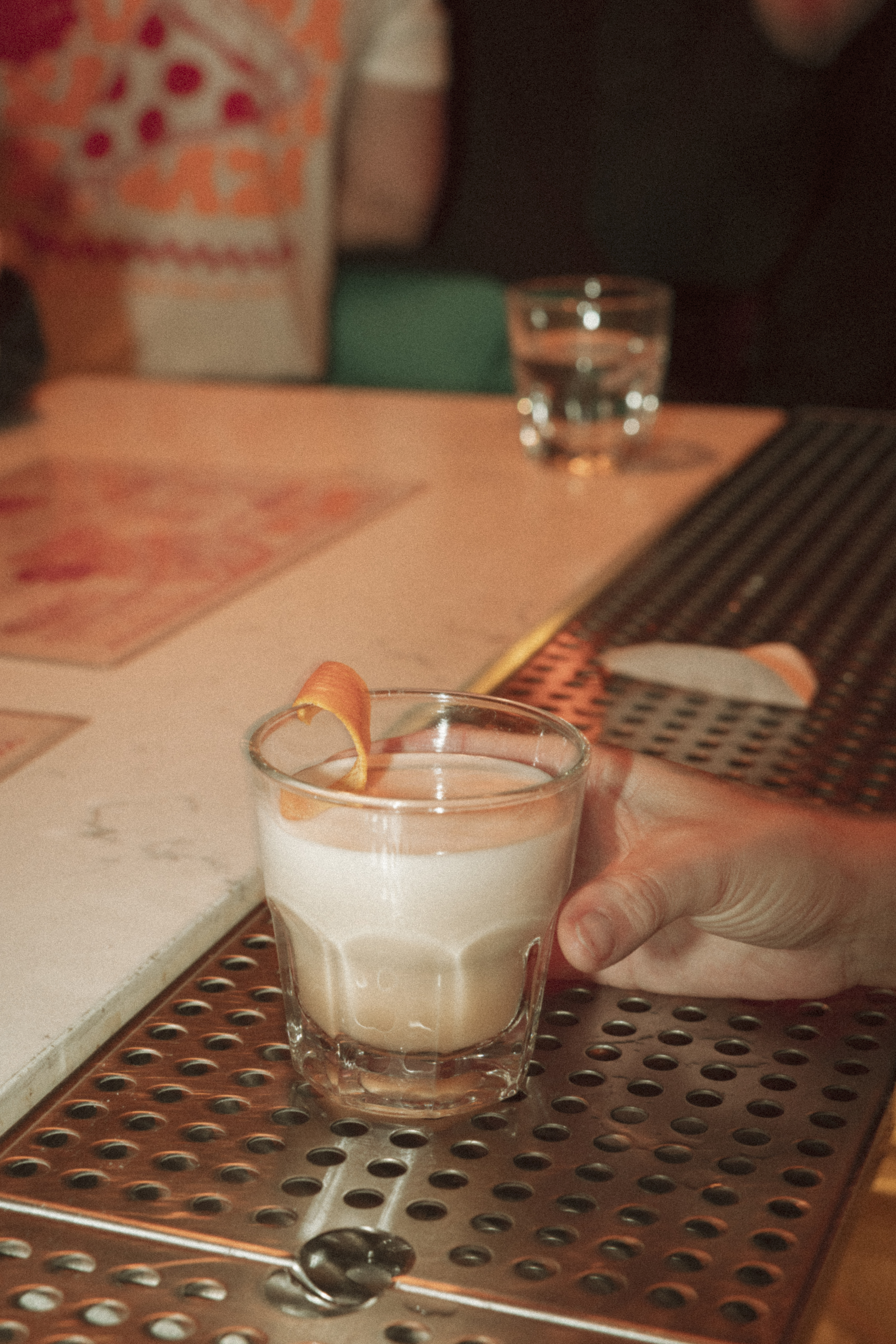 a hand holding a glass of liquid