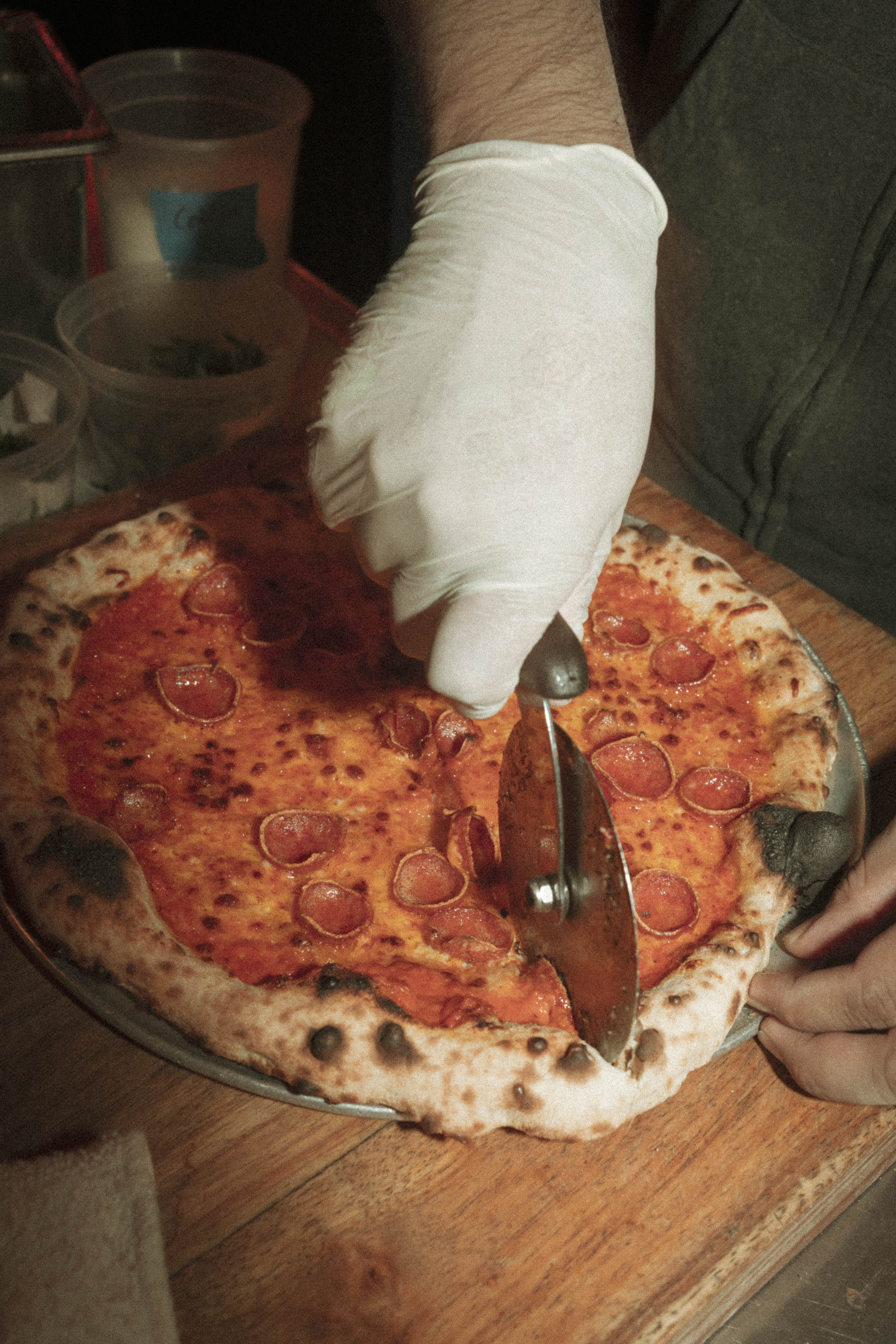 a person cutting a pizza