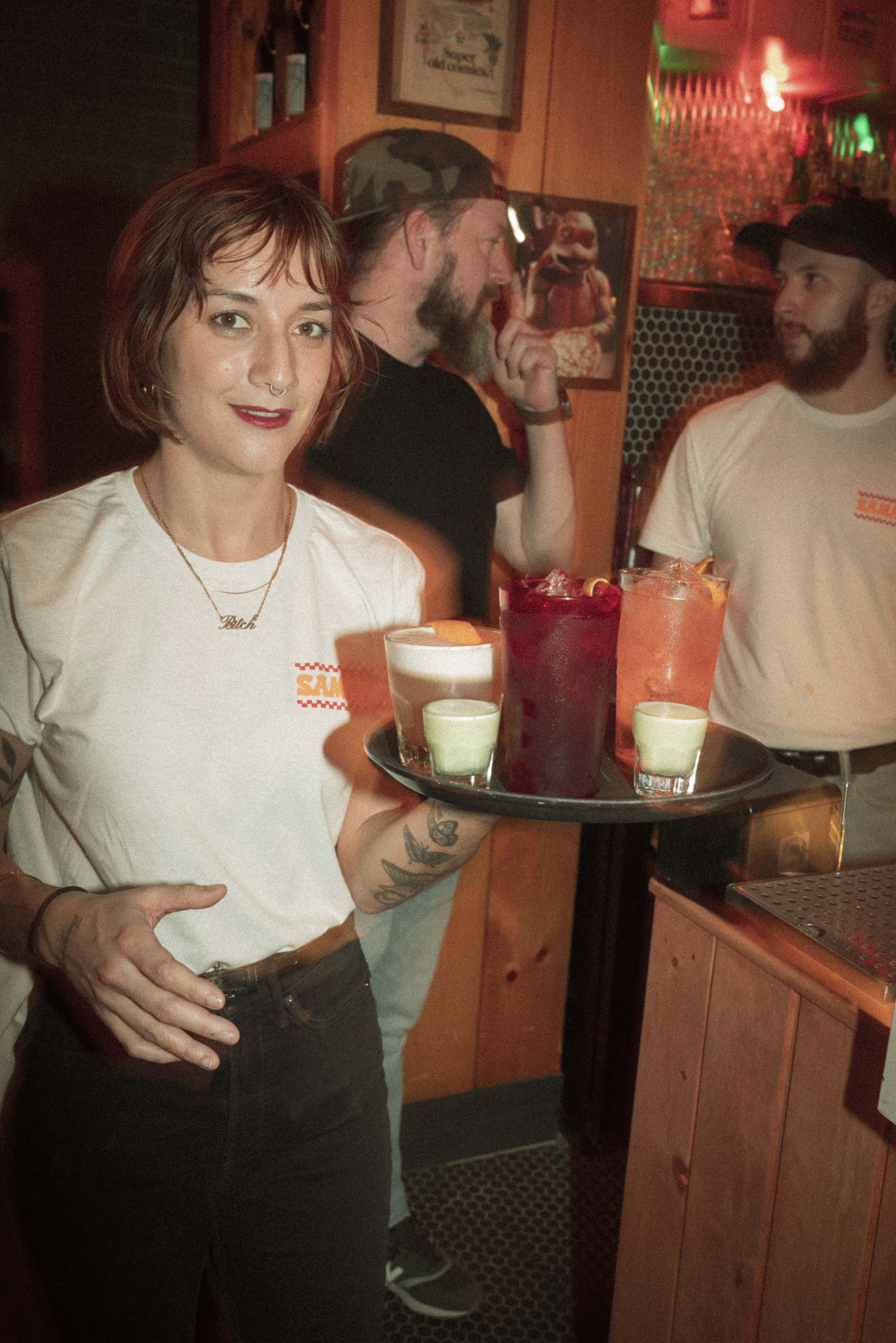 a woman holding a tray of drinks