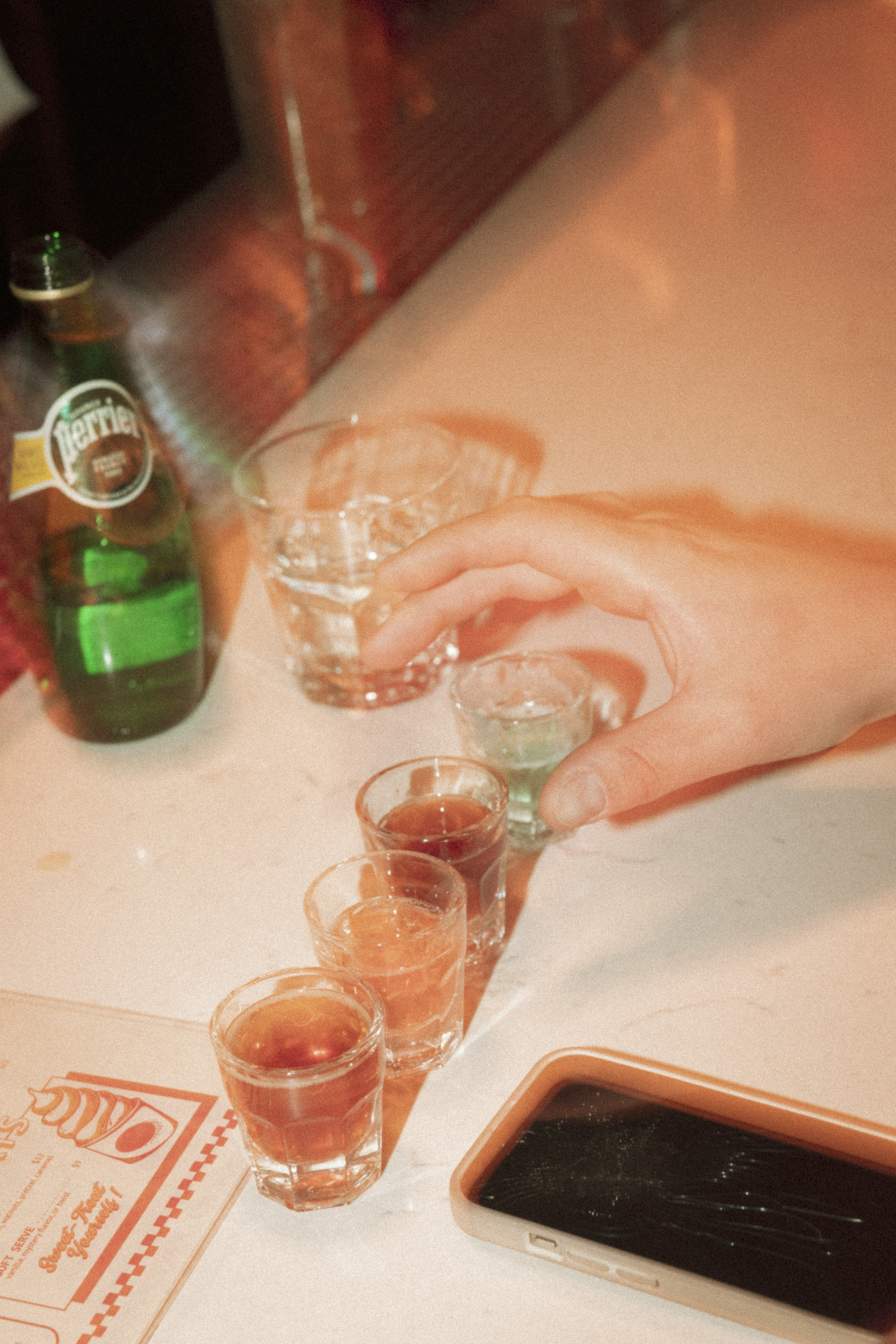 a hand holding a shot glass