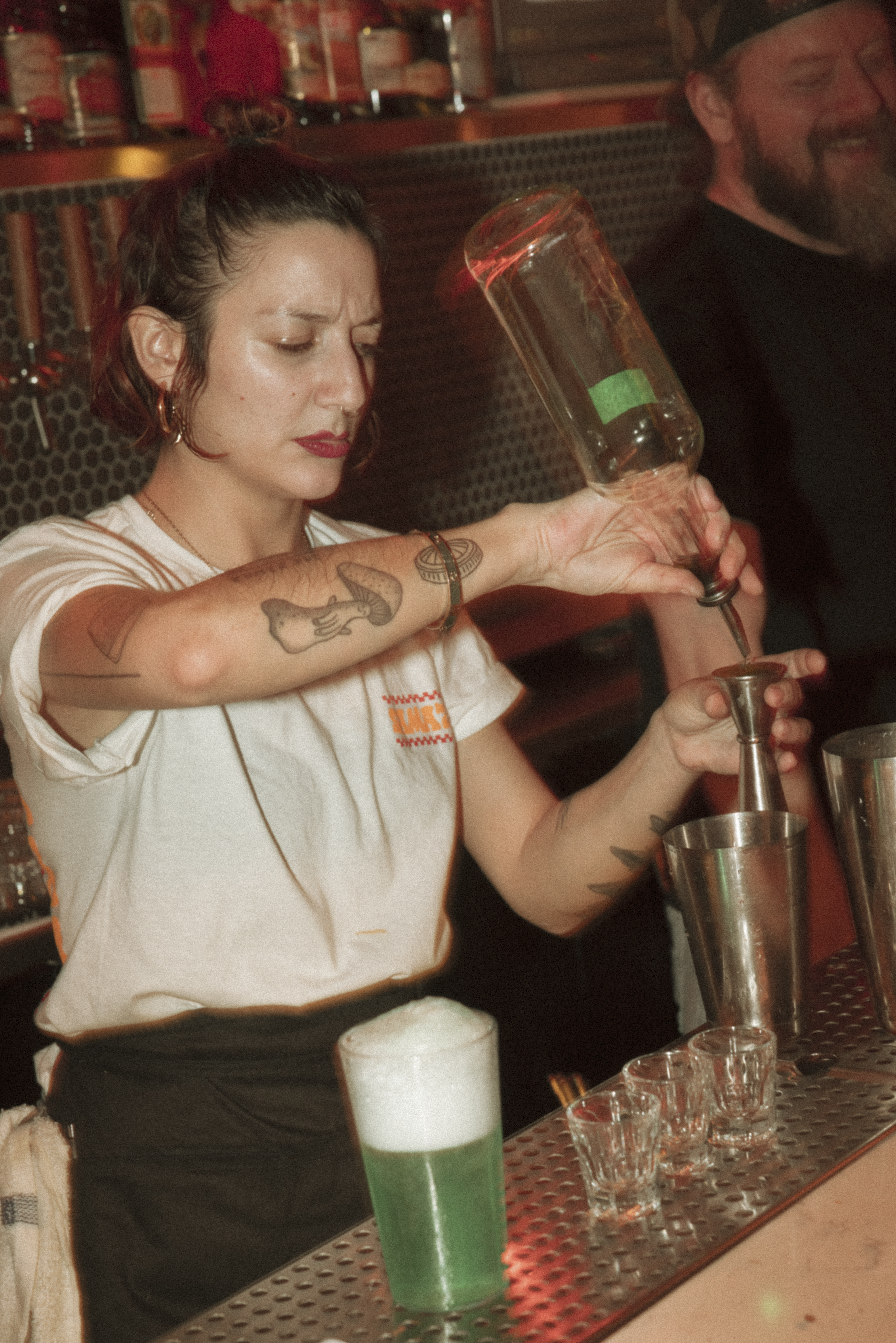 a woman pouring a drink into a glass